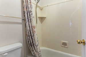 Full bathroom featuring shower / bath combo and toilet