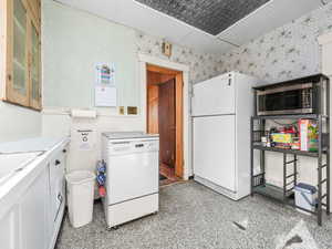 Kitchen with white appliances, white cabinets, light countertops, and an ornate ceiling