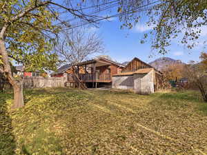 Back of house with a deck with mountain view and brick siding