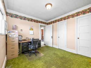 Home office featuring carpet floors, crown molding, and an ornate ceiling