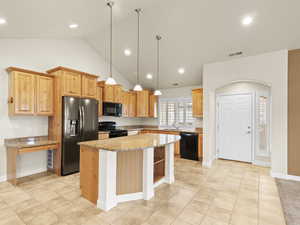 Kitchen featuring open shelves, black appliances, decorative light fixtures, a center island, and light tile patterned flooring