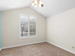 Additional living space with carpet floors, ceiling fan, and vaulted ceiling