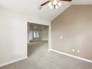 Unfurnished room with light carpet, lofted ceiling, and ceiling fan
