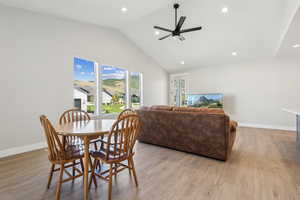 Dining area featuring vaulted ceiling, light wood-type flooring, recessed lighting, and ceiling fan