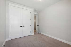 Unfurnished bedroom featuring carpet floors and a closet