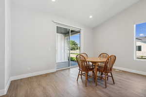 Dining area featuring light wood-type flooring, recessed lighting, and lofted ceiling