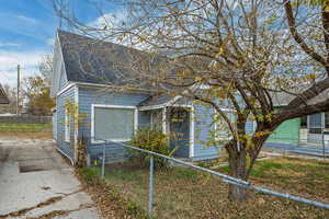 View of home's exterior with a fenced front yard and a shingled roof