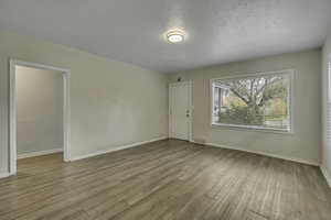 Spare room with light wood-type flooring and a textured ceiling