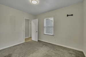 Carpeted empty room with baseboards
