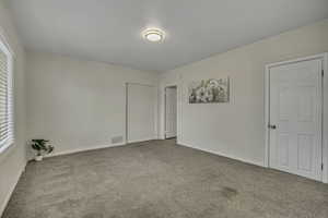 Unfurnished bedroom featuring light colored carpet and baseboards