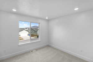 Carpeted empty room featuring baseboards and recessed lighting