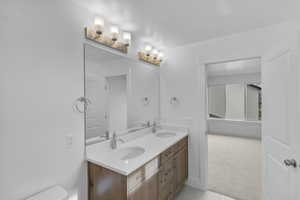 Full bathroom featuring double vanity, light colored carpet, and light tile patterned floors