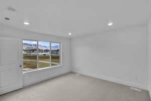 Spare room featuring light carpet, a mountain view, recessed lighting, a smoke detector, and a residential view