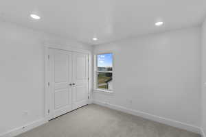 Unfurnished bedroom featuring carpet floors, a closet, and recessed lighting