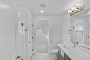 Full bath featuring vanity, light tile patterned floors, a shower stall, recessed lighting, and a walk in closet