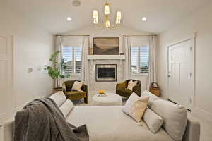 Living room featuring healthy amount of natural light, a chandelier, a tiled fireplace, lofted ceiling, and recessed lighting