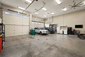 Garage featuring washer / clothes dryer, freestanding refrigerator, and white refrigerator