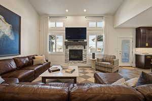 Living area featuring healthy amount of natural light, a stone fireplace, and recessed lighting