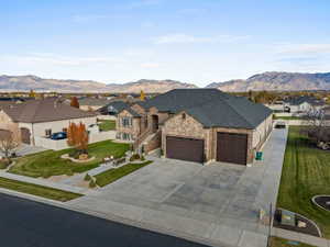 French country home featuring a residential view, a garage, concrete driveway, and a mountain view