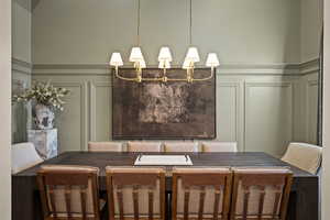 Dining space featuring a decorative wall and wainscoting