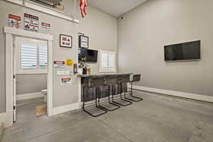 Indoor dry bar with plenty of natural light and a high ceiling