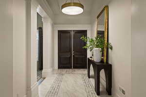 Doorway with marble finish floors and inlaid floor details