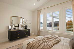 Bedroom with light colored carpet, recessed lighting, and vaulted ceiling