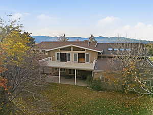 Aerial view of back of home, balcony, and covered patio.