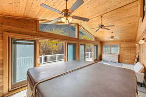 Sunroom / solarium featuring a jacuzzi and lofted ceiling. Large outdoor deck. featuring wood walls, access to outside, wood ceiling, high vaulted ceiling, and a sunroom