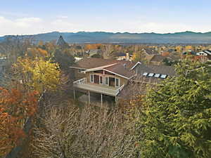 Aerial overview of property's location with a mountainous background and nearby suburban area