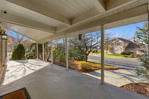 Expansive front porch overlooking landscaped yard.
