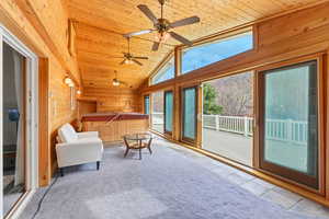 Sunroom featuring a hot tub and lofted ceiling