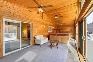 Sunroom / solarium featuring a jacuzzi and lofted ceiling. Large outdoor deck.