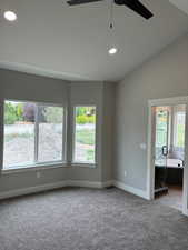 Master bedroom with vaulted ceiling and fan.