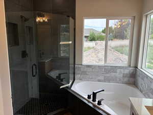 Master bathroom featuring a large garden tub and a walk in European glass shower.