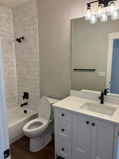 Full bath featuring vanity, tile from tub to ceiling and bathtub / shower combination