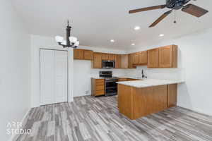 Kitchen with pendant lighting, a peninsula, tasteful backsplash, appliances with stainless steel finishes, and recessed lighting