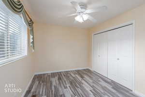 Unfurnished bedroom with wood finished floors, a closet, and ceiling fan