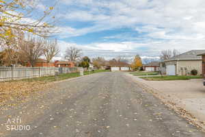 View of asphalt road featuring a residential view and curbs