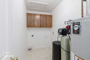 Laundry room with gas water heater, cabinet space, washer hookup, attic access, and electric dryer hookup
