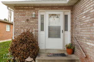 View of exterior entry with brick siding