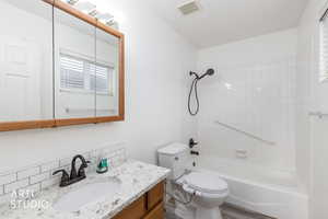 Full bath featuring tub / shower combination, vanity, decorative backsplash, and wood finished floors