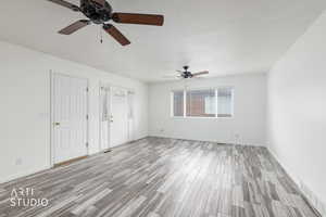 Unfurnished bedroom with a ceiling fan, light wood-style floors, and a closet