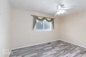 Spare room with a ceiling fan and wood finished floors