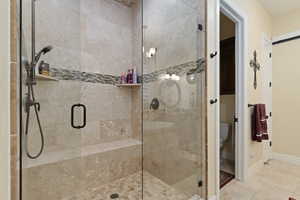 Bathroom with a shower stall and Travertine tile floors