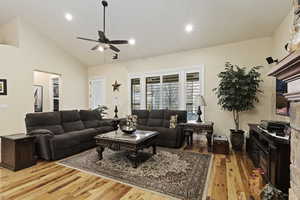 Living area with solid hardwood hickory flooring, vaulted ceiling, recessed lighting, and ceiling fan