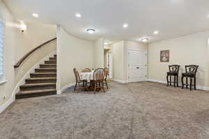 Family room with recessed lighting, light colored carpet, and stairway