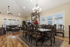 Dining room with 20 ft high vaulted ceiling, solid hardwood hickory flooring, a ceiling fan, recessed lighting, and a chandelier