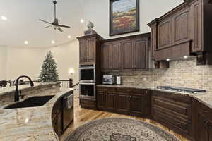 Kitchen with custom knotty alder cabinets, 20 ft towering vaulted ceiling, appliances with stainless steel finishes, Granite countertops, a center island with sink, solid hardwood hickory flooring.