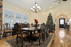 Dining space featuring a chandelier,solid hardwood hickory flooring, 20 ft high vaulted ceiling, and arched walkways